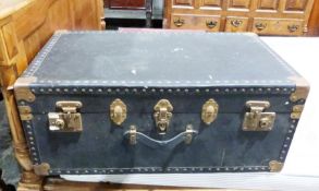 Travel trunk with brass fittings and patterned interior.