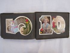 Album of vintage birthday cards in varying condition contained in brown British album.