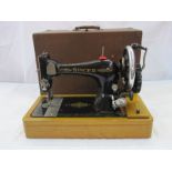 Singer sewing machine in wooden dome box with contemporary user manuals and extra parts including