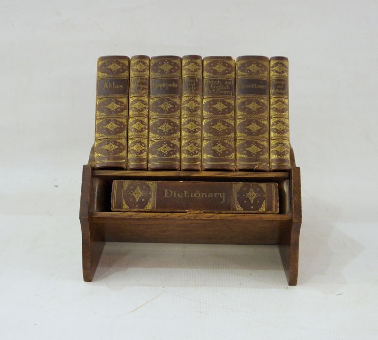 Small carved oak bookcase labelled Asprey, London, made in England containing reference library