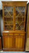 20th century yew bookcase cabinet, the moulded cornice above two astragal-glazed doors enclosing