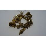 Rolled gold charm bracelet of double flattened-oval links and hung with 9ct gold charm of rococo