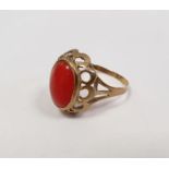 Gold-coloured metal and coral ring set oval cabochon stone, the ring marked '333'