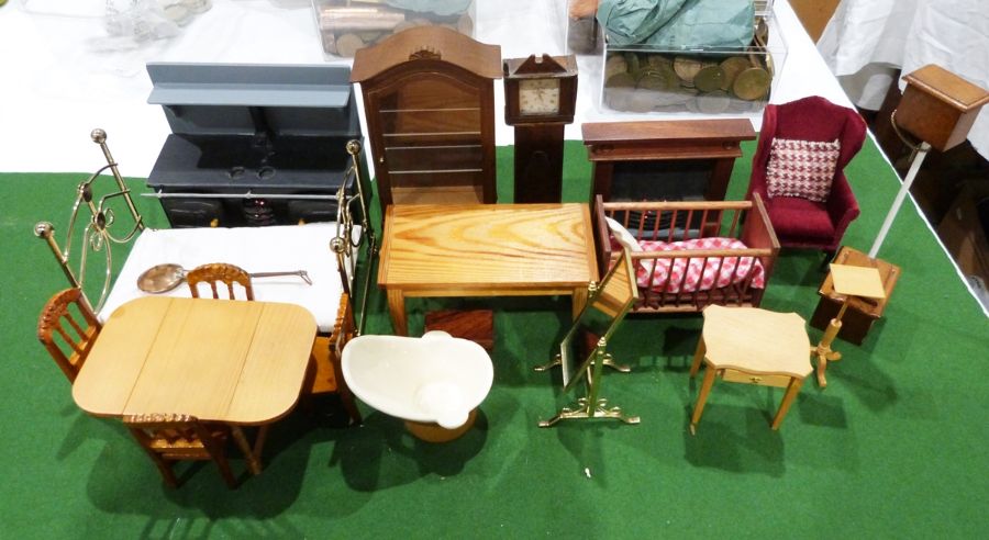 Quantity of dolls house furniture to include a dresser, bookcase, extending dining table, cot, brass