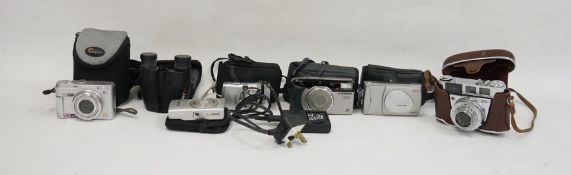 Kodak Retinette 1B camera, a Canon IXUS digital camera, a pair of Practika binoculars, a Panasonic