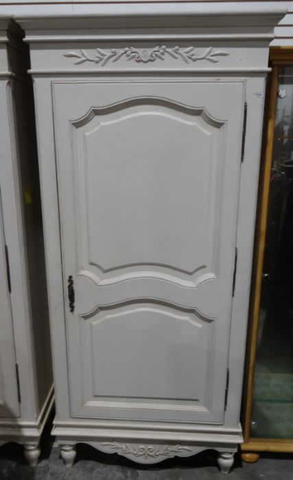 Two white painted armoires with applied moulded decoration, panelled doors, on turned supports (2)