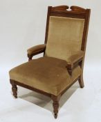 Edwardian oak-framed armchair with pale brown upholstered seat, back and armrests, on turned front