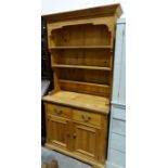 Modern pine dresser with assorted shelves above two drawers, two cupboard doors, on squat bracket
