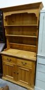 Modern pine dresser with assorted shelves above two drawers, two cupboard doors, on squat bracket