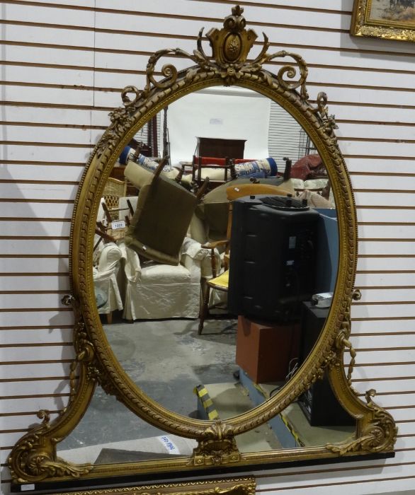 Regency overmantel wall mirror with gilt gesso frame above the oval plate and shaped mirror plate