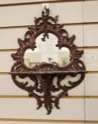 Possibly Victorian mirror with shaped glass plate in carved mahogany scrolling frame, with