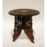 Eastern carved coffee table with bone inlay and folding carved base, 38cm diameter