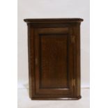 Oak wall-hanging corner cupboard with single cupboard door, on plinth base