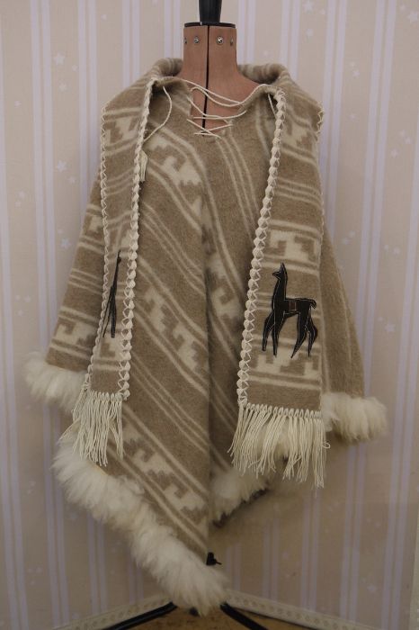 An Alpaca woollen poncho with tie front, matching scarf, fur trim and an appliqued alpaca onto the