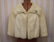 White mink short jacket with bracelet sleeves and a costume diamante broochCondition ReportAppears
