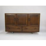 Ercol elm sideboard with oval dished handles, 3 cupboard doors above 2 drawers on casters (129cm