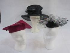 Box of two fascinators, one pink with hat pin with red pearl and the other black with multi-coloured