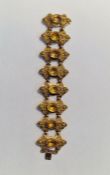 Gold-coloured metal ornate citrine set bracelet, each shaped panel set with oval citrine-coloured