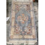 Chinese-style blue ground superwash rug with central dragon medallion, flanked by geometric