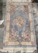 Chinese-style blue ground superwash rug with central dragon medallion, flanked by geometric