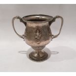 Possibly Indian silver-coloured metal two-handled cup with deity decoration, on circular foot