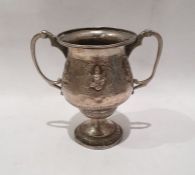 Possibly Indian silver-coloured metal two-handled cup with deity decoration, on circular foot