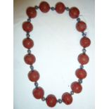 Oriental cinnabar and enamel shou necklace, the large cinnabar beads carved geometric design and