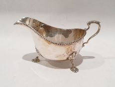 Silver sauceboat with beaded border, scroll handle, shell supports, London 1934