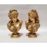 After A Carrier, pair of gilt metal busts, in neoclassical style,  with floral hair decorations,