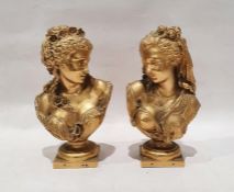After A Carrier, pair of gilt metal busts, in neoclassical style,  with floral hair decorations,