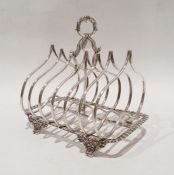 Victorian silver six-section toast rack with central foliate loop scroll handle, on gadrooned