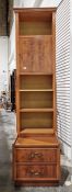 20th century narrow yew bookcase with moulded cornice above open shelves and cupboard doors, two
