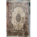 Five small silk rugs to include a cream ground rug with central oval floral medallion surrounded