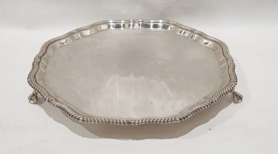 George V silver salver of circular lobed form, raised on three claw and ball feet, London 1923 by