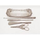 Silver-coloured tray with embossed scrolling and scallop decoration, a silver-handled button hook, a