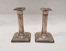 Pair of early 20th century weighted silver candlesticks of column form, on square bases by William