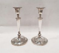 Pair of George V silver weighted candlesticks in the classical style, with tapered stand and stepped