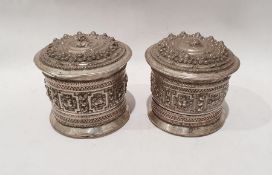 Pair of Burmese silver coloured metal lidded containers of cylindrical form with bull decoration,