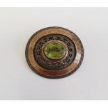 Silver, gold overlay and peridot brooch, oval central cut stone surrounded by pierced scroll and