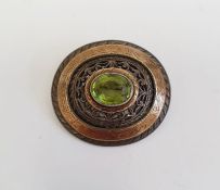 Silver, gold overlay and peridot brooch, oval central cut stone surrounded by pierced scroll and