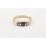 Gold-coloured, sapphire and diamond ring set central sapphire flanked by two old cut diamonds, in