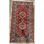 Modern Turkish style red ground rug with two central tekke guls flanked by a geometric border