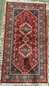 Modern Turkish style red ground rug with two central tekke guls flanked by a geometric border