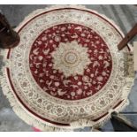 Large modern circular red ground rug with central floral medallion and multiple herati borders