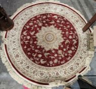 Large modern circular red ground rug with central floral medallion and multiple herati borders
