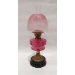 Duplex paraffin lamp with pink glass shade and well, brass body and on a circular base, approx. 58cm