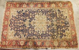 Persian rug with cream foliate pattern central medallion on a blue foliate decorated field with