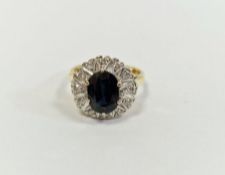 Sapphire and diamond cluster ring set centre rounded oblong sapphire and having surround of 12