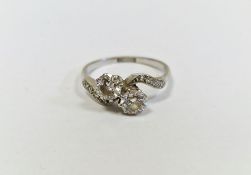 Platinum and diamond crossover ring set two claw-set diamonds with small diamonds to the