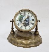 Mantle clock with the drum face with humorous barber image and ticking arm,  on circular plinth with